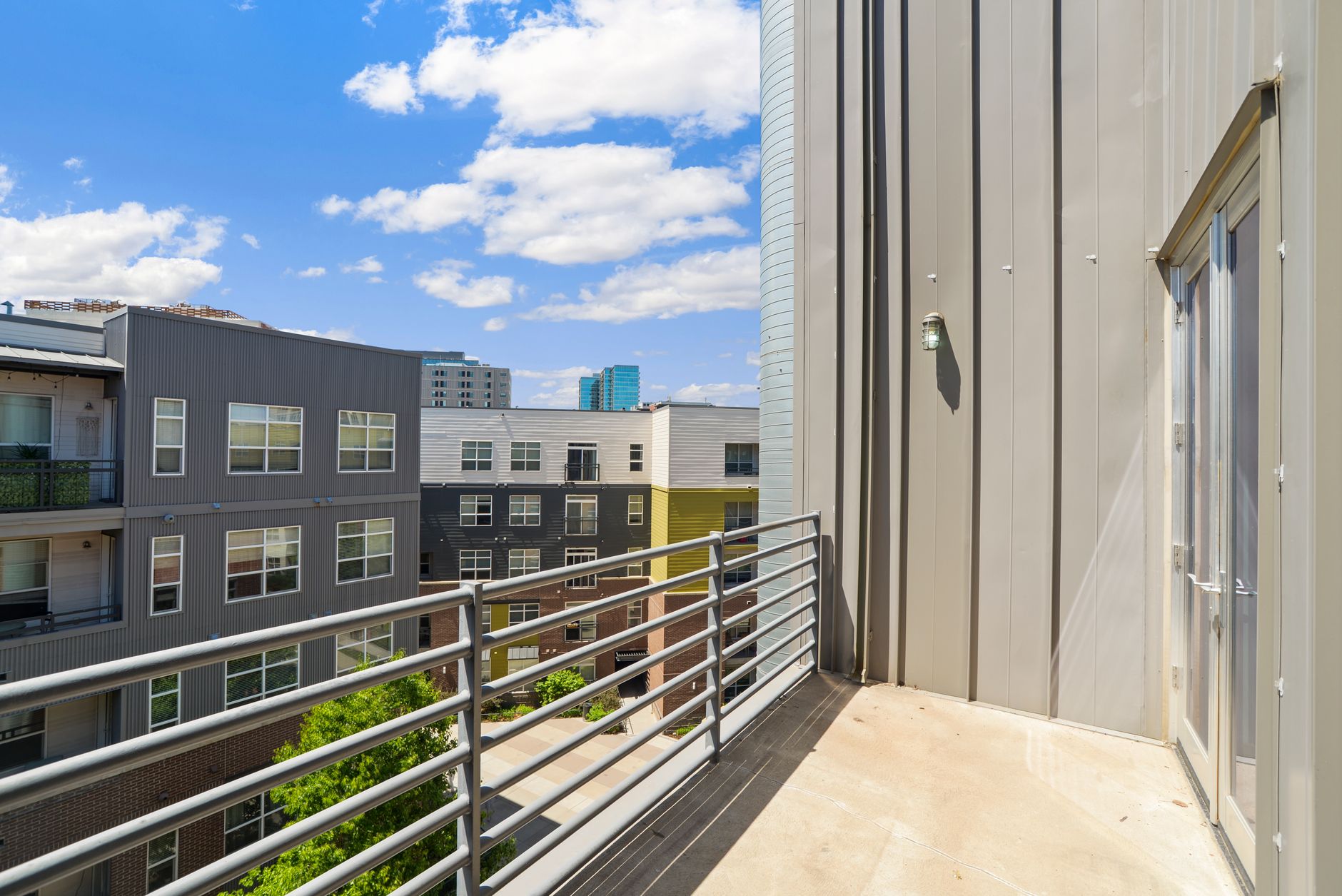 Exterior view of Upper Kirby Apartments highlighting modern architecture, sleek balconies, and vibrant city skyline.
