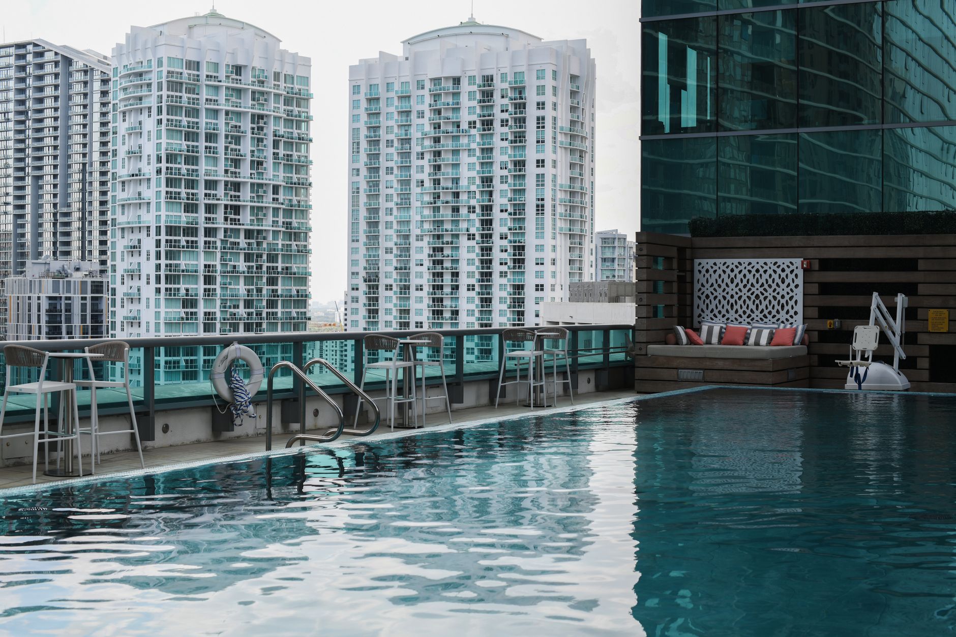 Foto tampak depan VE Hotel dengan arsitektur modern, kolam renang, dan taman hijau, cocok untuk liburan mewah di kota.