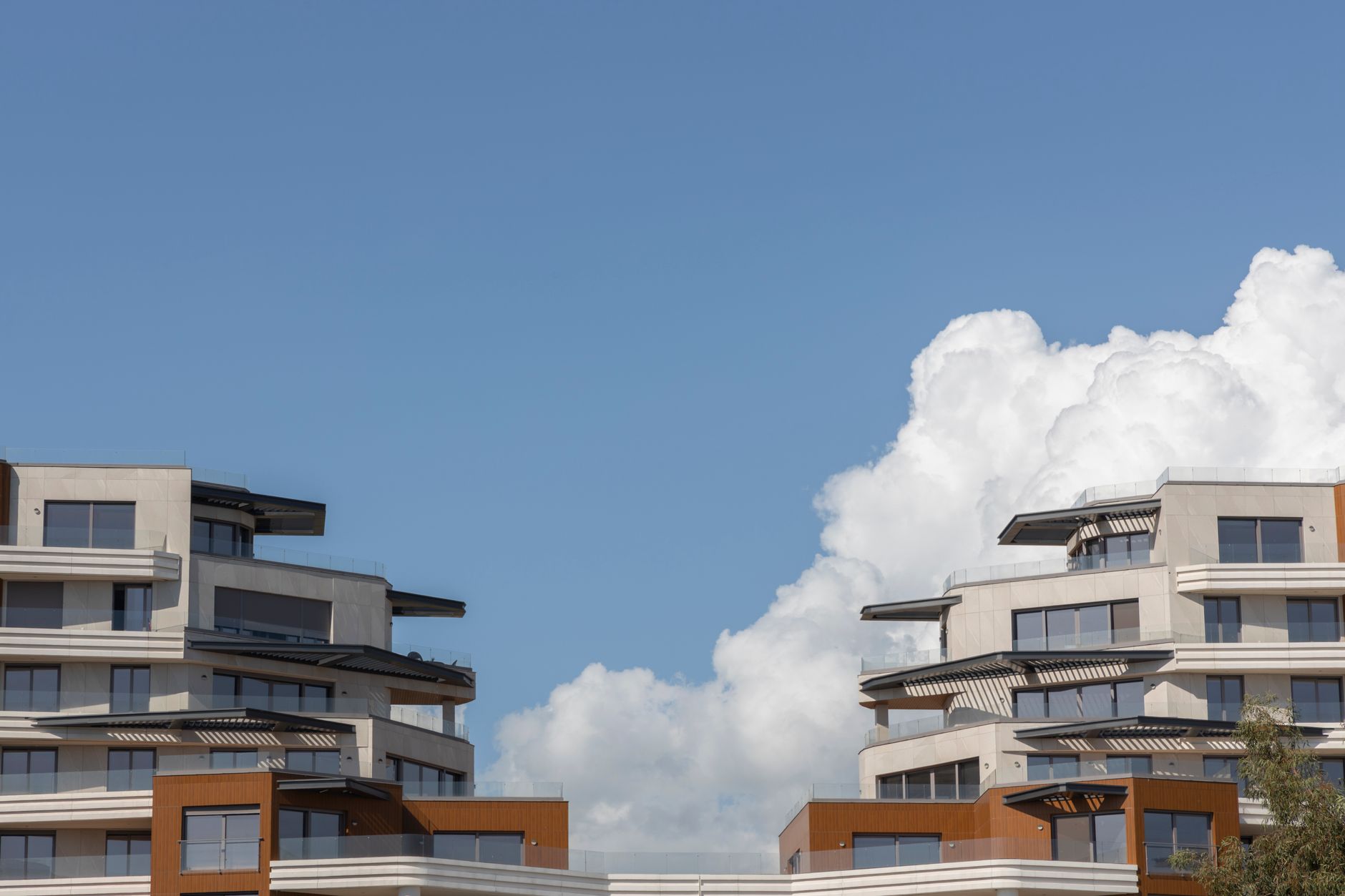 Gambar apartemen modern dengan desain minimalis, jendela besar, dan balkon luas di kota metropolitan