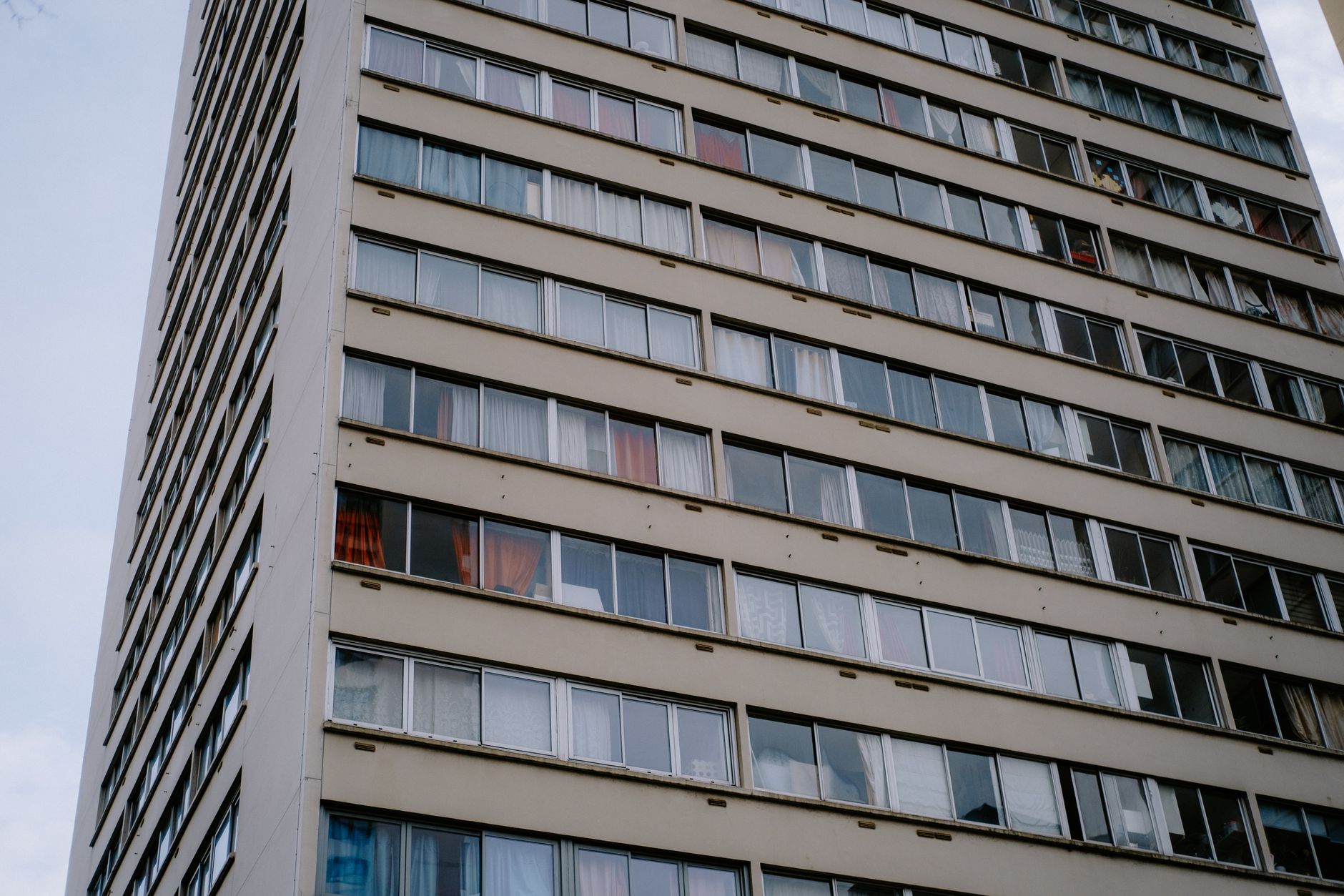 Gedung apartemen bertingkat tinggi dengan pencakar langit modern, menonjolkan fasilitas mewah dan pemandangan kota.