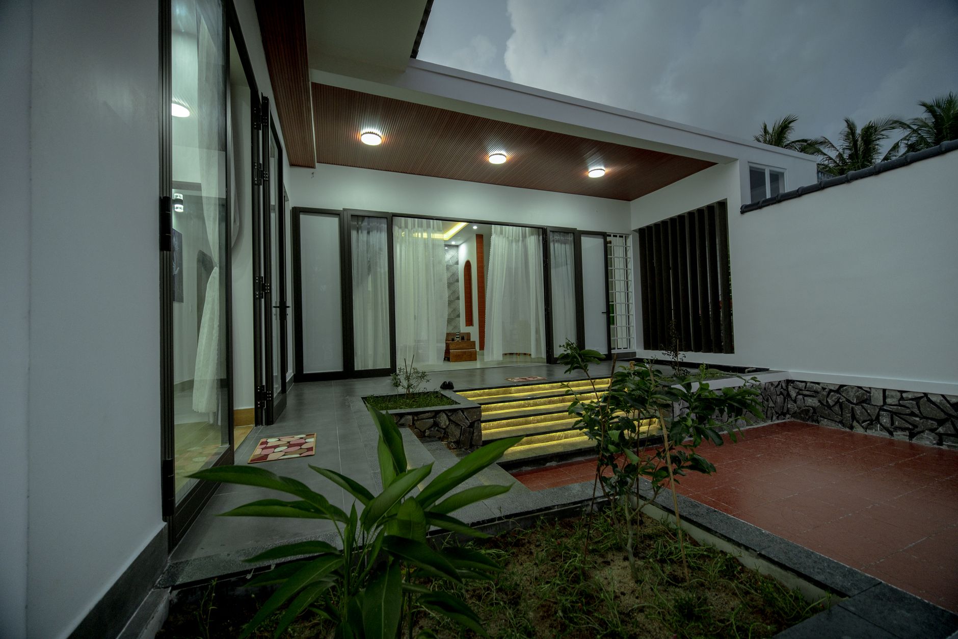 Aurora Residence dengan arsitektur modern, taman hijau, dan pencahayaan malam yang menawan