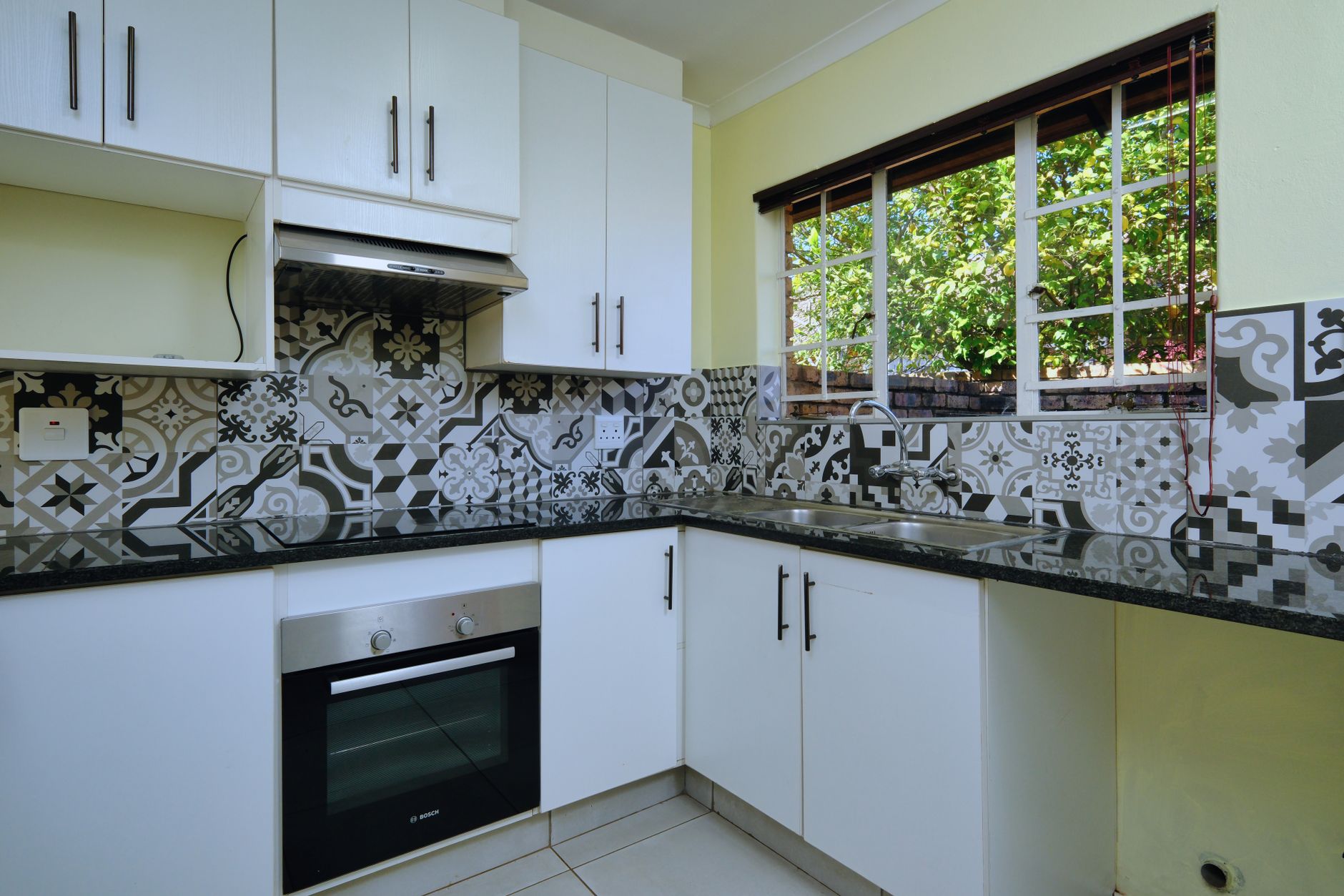 Gambar rumah modern tersedia untuk disewa, menampilkan taman luas dan ruang tamu terang
