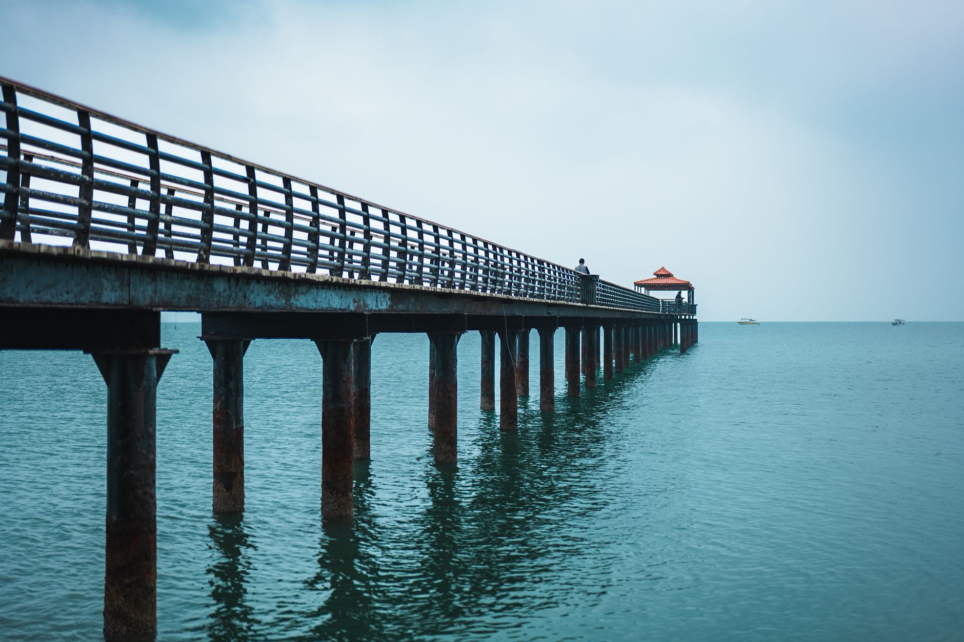 Foto menampilkan jetty modern dengan papan sewa yang menonjolkan layanan penyewaan perahu.